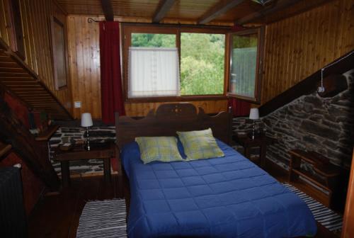 Pereje的住宿－Pereje Garden，一间卧室设有蓝色的床和窗户。