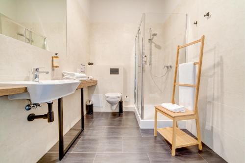 a bathroom with a sink and a shower and a toilet at GoldApartRooms in Białystok
