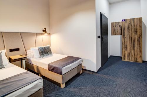 a hotel room with two beds and a door at GoldApartRooms in Białystok