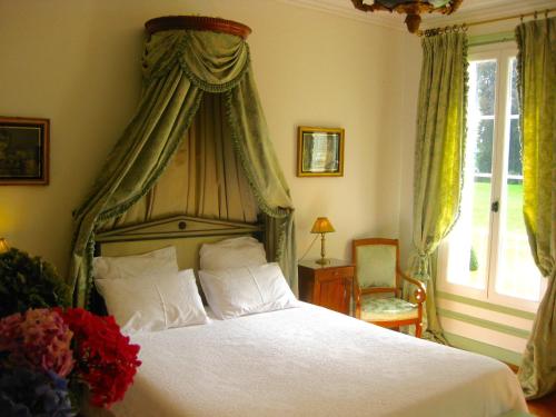 a bedroom with a large bed with a canopy at Château de Cleuville in Cleuville