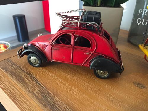 a red toy car with luggage on top of it at The One Suite Annecy in Annecy