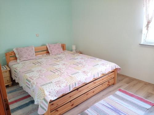 a bedroom with a bed with a pink comforter at Raj Muraj Ferienappartement in Kornić