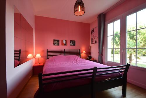 a bedroom with red walls and a bed with pink sheets at Villa Florida in Le Bugue