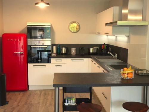a kitchen with a red refrigerator and white cabinets at The One Suite Annecy in Annecy