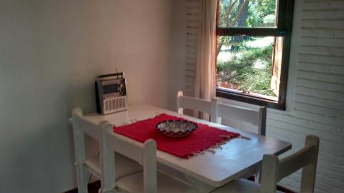 una piccola sala da pranzo con tavolo e forno a microonde di Bungalow en Pinamar a Pinamar