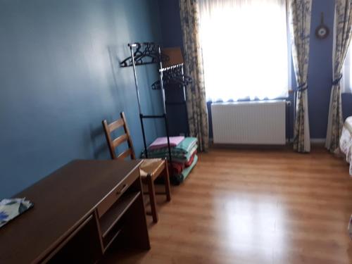 Cette chambre comprend un bureau, une table et une fenêtre. dans l'établissement Le Gîte de Ambre, à Grand