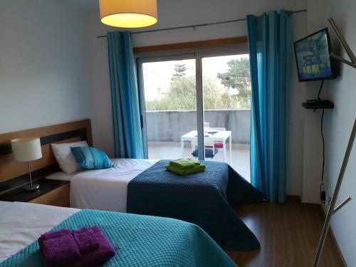 a hotel room with two beds and a window at Apartamento BaySide - São Martinho do Porto in São Martinho do Porto