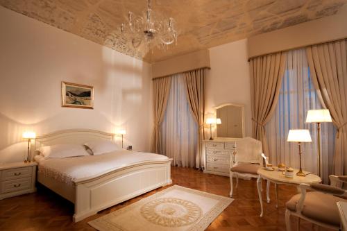 1 dormitorio con 1 cama, 1 silla y 1 mesa en Antiq Palace - Historic Hotels of Europe en Liubliana