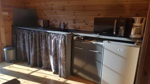 een keuken met een magnetron en een koelkast bij POD des deux chênes in Louroux-Hodement