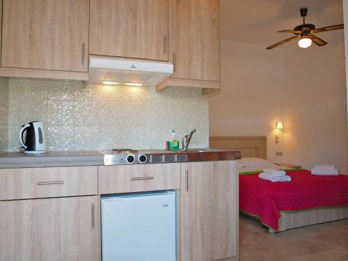 a kitchen with a sink and a bed in a room at Nikos Hotel in Matala