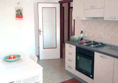 een keuken met een fornuis en een fruitschaal op een tafel bij Confortevole appartamento nel cuore di Termoli in Termoli