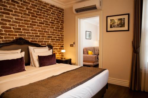 pokój hotelowy z łóżkiem i ceglaną ścianą w obiekcie Meroddi Pera Flats w Stambule