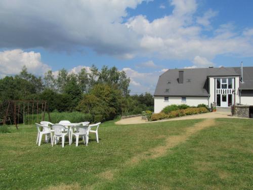 a table and chairs in front of a white building at Energîte in Tillet