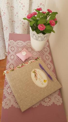 a table with a vase of flowers and a envelope at Sol y Sombra Apartamento con entrada independiente in Isla del Moral