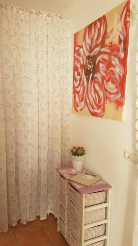 a room with a white curtain and a dresser with a plant at Sol y Sombra Apartamento con entrada independiente in Isla del Moral