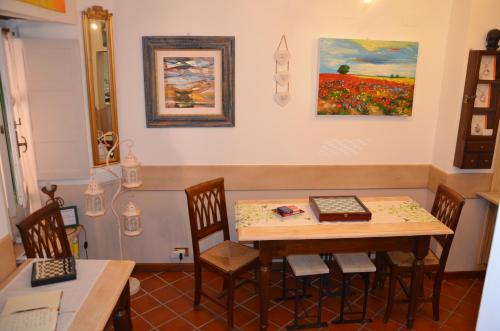 a dining room with a table and chairs and a painting at Il Torrione in Castiglione del Lago