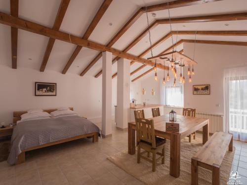 ein Schlafzimmer mit einem Bett und einem Tisch sowie ein Esszimmer in der Unterkunft Bergkranc Hotel & Resort in Pale