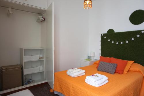 a bedroom with an orange bed with towels on it at Mai City Apartment in Las Palmas de Gran Canaria