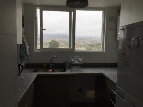 拉塞雷納的住宿－Departamento La Serena 6 Personas，厨房设有水槽和窗户。