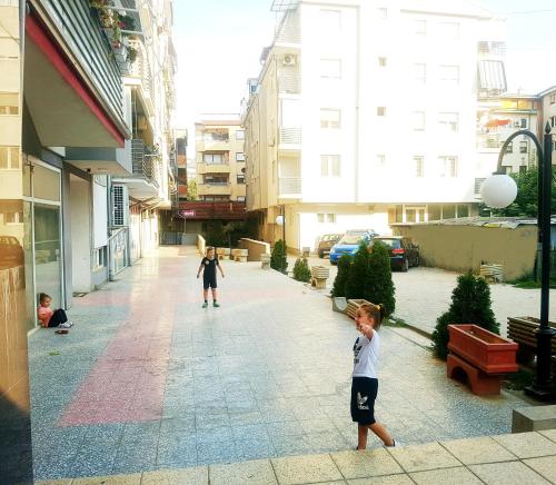 two children playing on a street in a city at Tetovo Apartment Superb Location in Tetovo