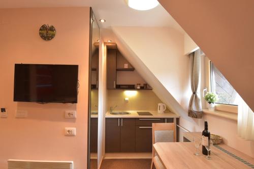 a small kitchen with a kitchen under a staircase at Apartment Ski Star Konaci in Kopaonik