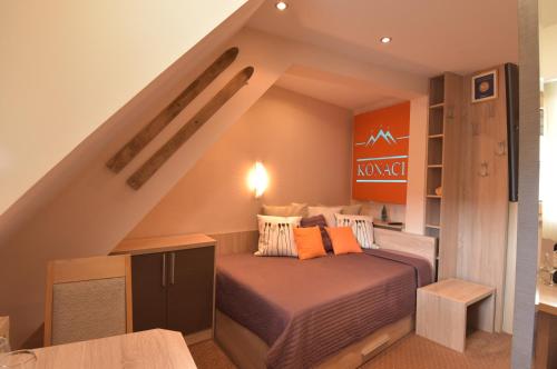 a small bedroom with a bed in a attic at Apartment Ski Star Konaci in Kopaonik