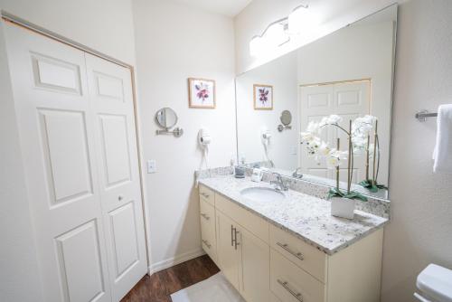 a bathroom with a sink and a large mirror at Dream Vacation Home! in Kissimmee