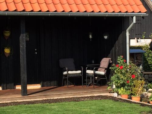 two chairs and a table in a black shed at Troense Bed and Breakfast by the sea in Svendborg