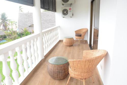 a porch with two chairs and a table on it at Villa Dahl Beach Resort in Dar es Salaam