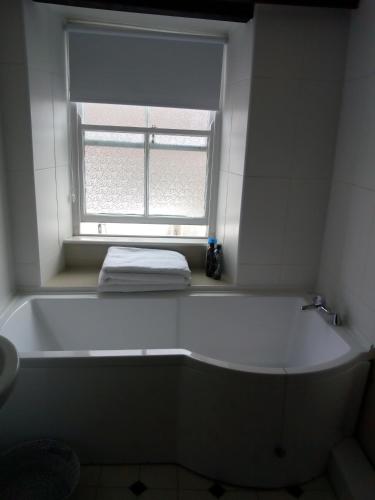 a white bath tub in a bathroom with a window at The Old Tea House in Dorchester