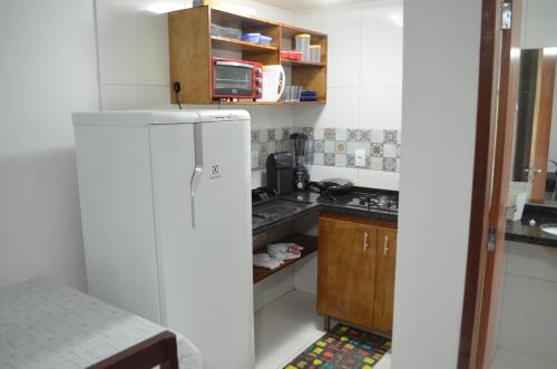 a small kitchen with a refrigerator and a sink at Residencial Fran Chiattone in Natal