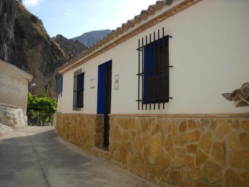 un bâtiment avec deux fenêtres et une porte bleue dans l'établissement Casa Rural El Balcón de Cazorla, à Tiscar