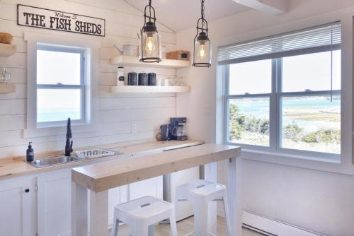 a kitchen with a large counter with stools in it at The Fish Sheds in Rocky Harbour