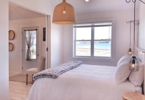 1 dormitorio con 1 cama y vistas a la playa en The Fish Sheds en Rocky Harbour