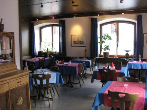 Garni Fluela Susch في سيور: مطعم بالطاولات والكراسي مع قماش الطاولة الزرقاء والحمراء