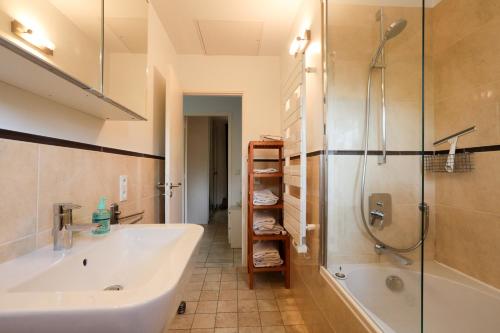 a bathroom with a tub and a shower and a sink at Rêve de Provence Villa avec jardin et piscine in Forcalquier