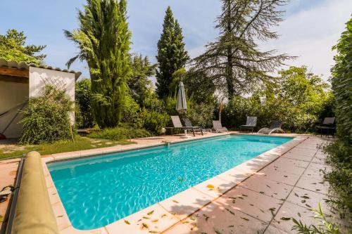 - une piscine dans un jardin avec des chaises et des arbres dans l'établissement Rêve de Provence Villa avec jardin et piscine, à Forcalquier