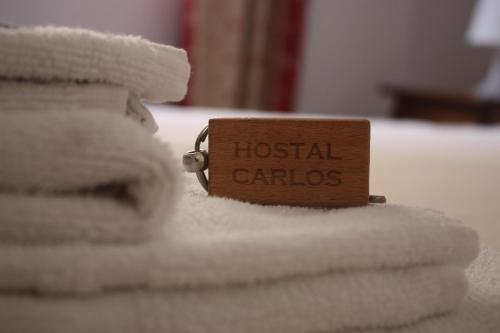 a wooden tag on a bed with towels at Hostal Carlos 2 in La Línea de la Concepción