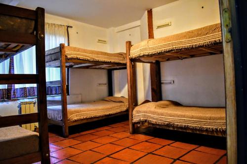 a room with three bunk beds in a house at Rancho Aparte Hostel in El Chalten
