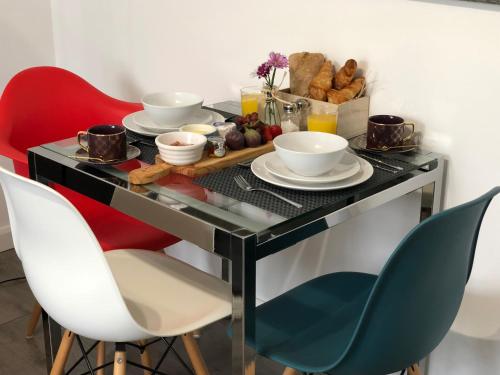a table with plates and bowls on it with chairs at La casetta d'Àneu in Oxford
