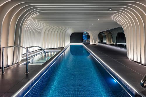 a swimming pool in a building with a tunnel at SKYE Suites Sydney in Sydney