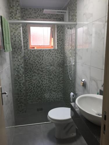 a bathroom with a shower and a toilet and a sink at Apartamento em Canela in Canela