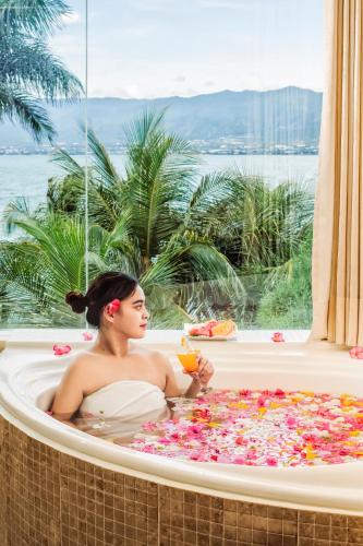 a woman sitting in a bath tub filled with flowers at Swiss-Belhotel Silae Palu in Palu