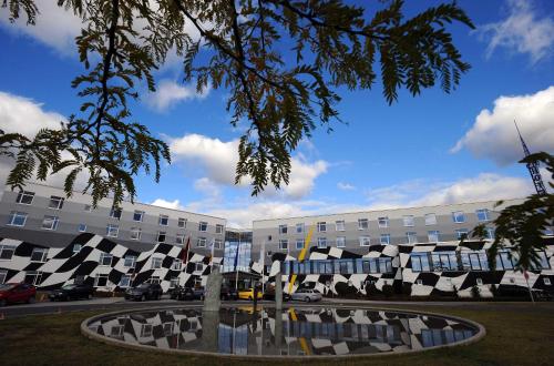 
a large fountain surrounded by palm trees at Hotel Motorsport Arena in Oschersleben
