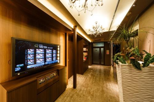 a hallway with a flat screen tv on a wall at HOTEL MYTH-Resort -ホテル マイス リゾート- adult only in Nagato
