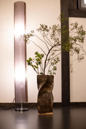 a vase with a plant in it next to a lamp at JINYA Fujikawaguchiko in Fujikawaguchiko