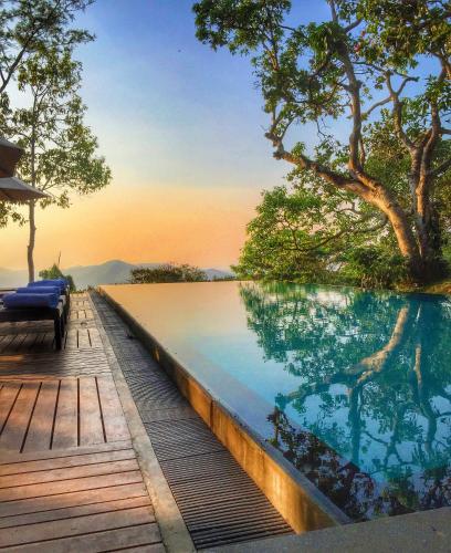 a swimming pool with a deck and a view of the ocean at Mountbatten Bungalow- Thema Collection in Kandy