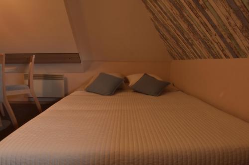a bed with two pillows in a small room at Apartment Sofia-Konaci in Kopaonik