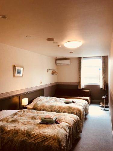 a hotel room with two beds and a window at Resort Inn Marion Shinano in Otari