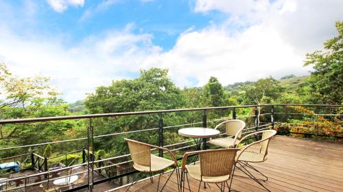 a balcony with a table and chairs on a wooden deck at Pear Story House in Dongshi